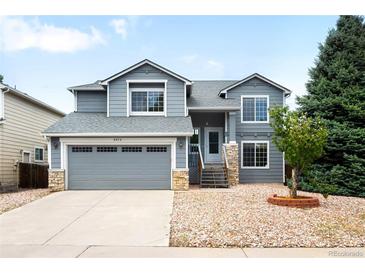 Charming two-story home boasts a well-manicured lawn, inviting entrance, and attached two-car garage at 8879 Apache Plume Dr, Parker, CO 80134