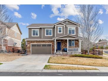 Charming two-story home with stone accents, inviting front porch, and well-manicured landscaping at 23469 E Briarwood Pl, Aurora, CO 80016