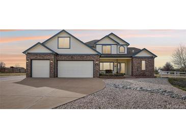 Charming two-story home with a brick accent, a spacious three-car garage, and a beautifully landscaped front yard at 16665 Kenuil St, Brighton, CO 80603