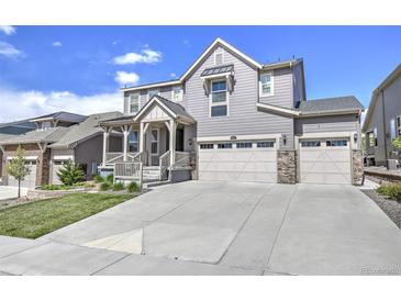 Charming two-story home with a three-car garage, covered porch and well-manicured lawn at 7167 Hyland Hills St, Castle Pines, CO 80108