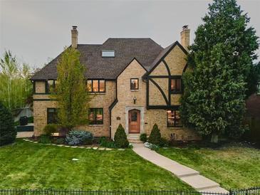 Charming brick home with a well-manicured lawn, mature trees, and an inviting walkway leading to the front door at 3811 E 26Th Avenue Pkwy, Denver, CO 80205
