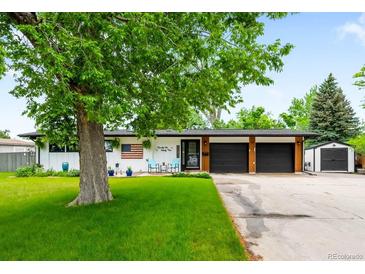 Charming ranch-style home featuring a well-manicured lawn and an attached two-car garage at 7695 S Sheridan Ct, Littleton, CO 80128
