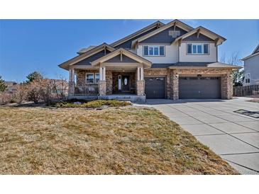 Inviting two-story home with a stone facade, covered porch, and a two-car garage at 6236 S Robertsdale Ct, Aurora, CO 80016