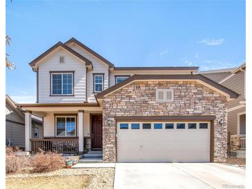 Charming two-story home with a stone facade, covered porch, and well-maintained landscaping at 5032 S Valdai Way, Aurora, CO 80015