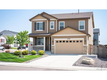 Charming two-story home featuring a two-car garage, covered porch, and well-manicured lawn at 27790 E 9Th Pl, Aurora, CO 80018