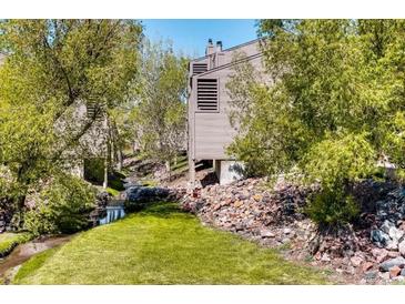 Tan siding townhouse exterior with a creek and green space at 6700 W 11Th Ave # 205, Lakewood, CO 80214