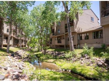 Complex exterior showing building and landscaping next to a creek at 6700 W 11Th Ave # 205, Lakewood, CO 80214