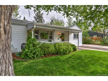 Charming home with beautiful green lawn, landscaped garden and inviting front porch at 2083 W Arbor Ave, Littleton, CO 80120