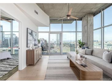 Open concept living room featuring large windows, modern decor, and a balcony at 1700 Bassett St # 1106, Denver, CO 80202