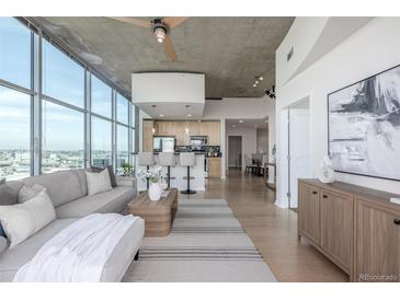Bright living room featuring floor-to-ceiling windows and an open concept to the modern kitchen at 1700 Bassett St # 1106, Denver, CO 80202