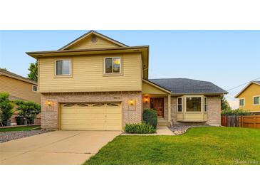 Two-story home with attached garage and manicured lawn at 9670 W 70Th Ave, Arvada, CO 80004