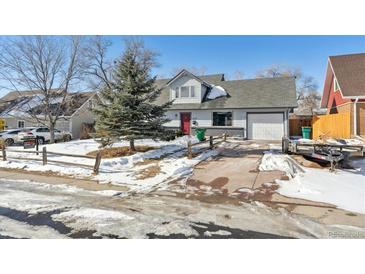 Charming home featuring a well-maintained front yard, attached garage, and inviting red door at 639 Quartz Way, Broomfield, CO 80020