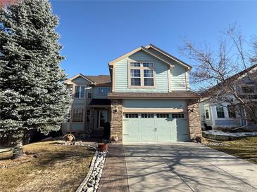 Charming two-story home featuring a well-maintained lawn and attached two-car garage, complemented by a brick accent at 6044 S Yakima St, Aurora, CO 80015