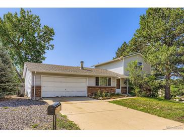 Charming two-story home with a two-car garage and mature trees in a residential neighborhood at 7542 Otis St, Arvada, CO 80003