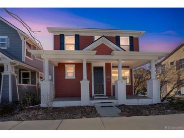Charming two-story home features a welcoming front porch with stately white columns at 2983 Fulton St, Denver, CO 80238