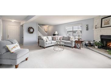 Inviting living room featuring plush seating, neutral tones, fireplace, and ample natural light at 60 S Moline St, Aurora, CO 80012