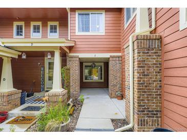 Inviting townhome exterior with brick pillars, covered entrances, and homey welcome decor at 19440 E Mann Creek Dr # E, Parker, CO 80134
