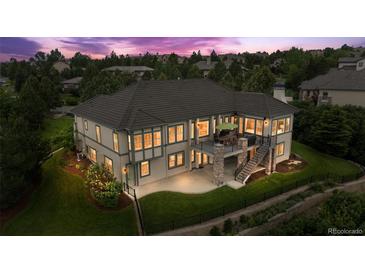 Beautiful home with a patio, deck, and lush landscaping; a great space for outdoor entertaining and relaxation at 6303 Ellingwood Point Pl, Castle Rock, CO 80108