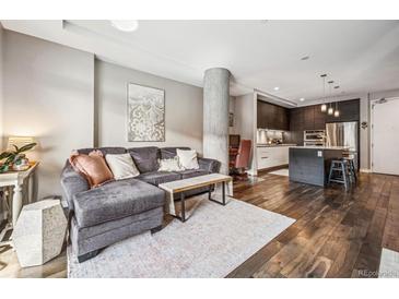 Inviting living room featuring hardwood floors, stylish decor, comfortable seating and an open concept to the kitchen at 4200 W 17Th Ave # 327, Denver, CO 80204