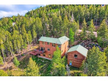 Beautiful wood home nestled in a lush forest with a deck perfect for enjoying nature at 11876 Coal Creek Heights Dr, Golden, CO 80403