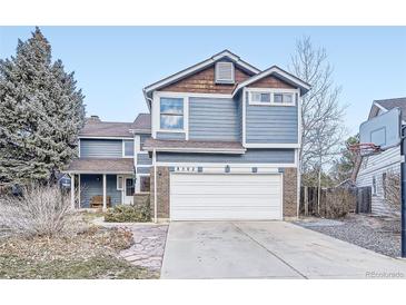 Charming two-story home with a well-manicured front yard and attached two car garage at 8502 Oak St, Arvada, CO 80005