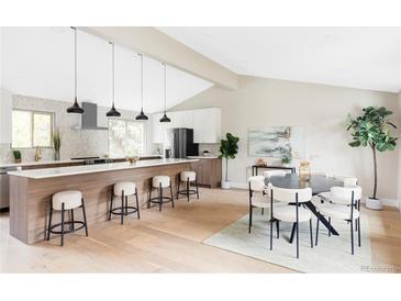 Modern kitchen with island, stainless steel appliances, and white shaker cabinets at 7348 S Lafayette W Cir, Littleton, CO 80122