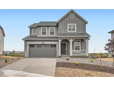 Charming two-story home with a gray exterior, covered front porch, and manicured front yard at 11039 Snowdon St, Parker, CO 80134