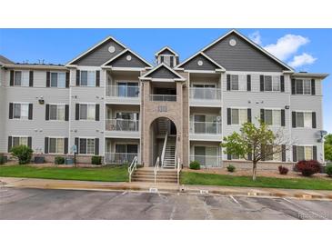Exterior of a three-story condominium building with brick and siding and walkways to unit doors and balconies at 15700 E Jamison Dr # 3-307, Englewood, CO 80112