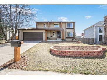 Charming two-story home featuring a well-manicured front yard and attached two-car garage at 18438 E Berry Dr, Centennial, CO 80015