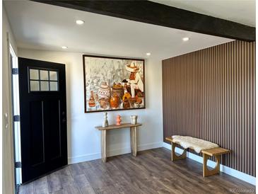 Inviting foyer featuring wood floors, contemporary decor, and an eye-catching accent wall at 1285 Roslyn St, Denver, CO 80220