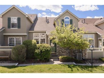 Charming townhome featuring stone accents, landscaped front yard, and a welcoming facade at 10183 Grove Loop # D, Westminster, CO 80031