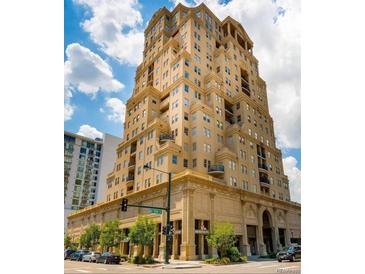Stylish building with an impressive tan brick design under a bright blue sky with fluffy white clouds at 300 W 11Th Ave # 18C, Denver, CO 80204