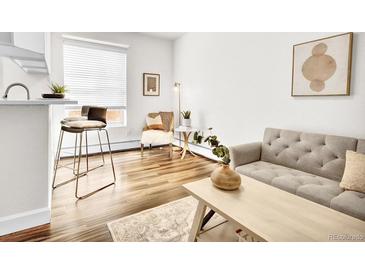 Bright living room featuring hardwood floors, modern furnishings, and ample natural light at 1629 N Clarkson St # 23, Denver, CO 80218
