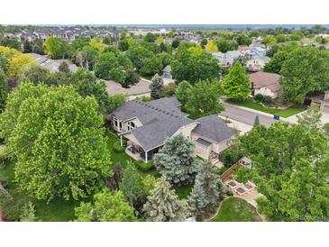 An aerial view of a charming home surrounded by lush greenery and mature trees at 3144 Stevens N Cir, Erie, CO 80516