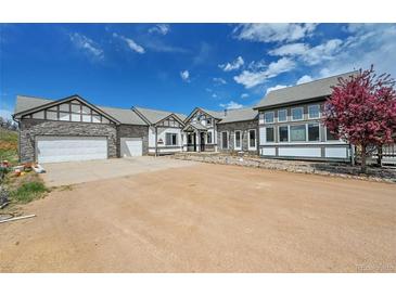 Charming home featuring stone accents, inviting curb appeal, and a spacious driveway at 3794 N State Highway 67, Sedalia, CO 80135