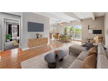 Cozy living room features hardwood floors, large TV, and flows into dining area with outdoor access at 1441 N Humboldt St # 204, Denver, CO 80218