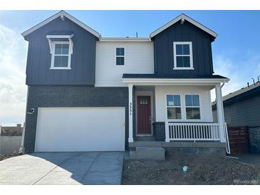 Charming two-story home featuring a brick facade, covered porch, and a two-car garage at 3351 N Buchanan Way, Aurora, CO 80019