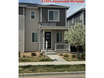 Two-story home featuring stone accents, a covered porch, and a landscaped front yard in a residential neighborhood at 9667 Walden St, Commerce City, CO 80022