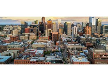 An aerial view of a bustling cityscape at sunset showing numerous skyscrapers in a dense urban environment at 1750 Wewatta St # 830, Denver, CO 80202