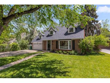 Charming brick home with lush front yard and well-maintained landscaping, driveway and garage at 400 Holly St, Denver, CO 80220