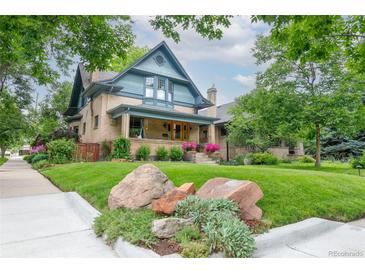 Charming two-story brick home with a beautifully landscaped front yard and inviting front porch at 3701 Eliot St, Denver, CO 80211