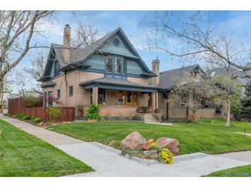 Charming brick two-story home with manicured lawn, mature trees, and inviting front porch at 3701 Eliot St, Denver, CO 80211