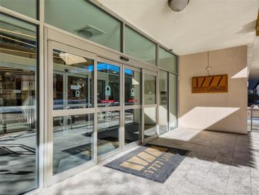 Modern building entrance with glass doors and a welcoming mat at 1777 Larimer St # 1908, Denver, CO 80202