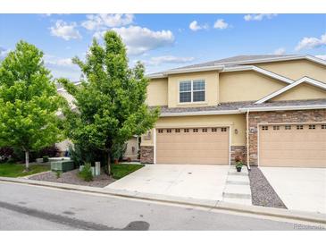 Inviting two-story home featuring a two-car garage and stone accents at 22391 E Plymouth Cir, Aurora, CO 80016