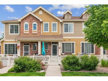 Charming two-story townhouse with brick accents, covered front porch, white picket fence and manicured landscaping at 16031 W 63Rd Ln # D, Arvada, CO 80403