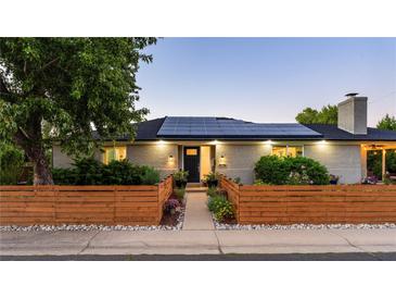 Charming brick home with a manicured front yard and solar panels on the roof, perfect for energy efficiency at 6303 E Dakota Ave, Denver, CO 80224