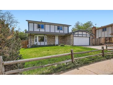 Charming two-story home featuring stone accents, a well-manicured lawn, and a welcoming two-car garage at 8897 Wagner Ln, Westminster, CO 80031