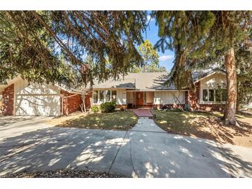 Charming single-story brick and siding home with a tile roof, landscaped yard, and a long concrete driveway at 4862 Silver Sage Ct, Boulder, CO 80301