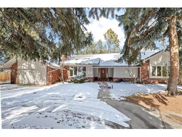 Charming brick home with a snowy front yard and mature trees at 4862 Silver Sage Ct, Boulder, CO 80301