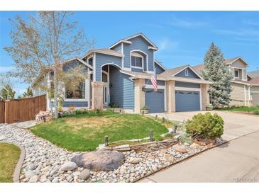 Charming two-story home featuring a well-maintained lawn, rock garden and a two-car garage at 9371 Desert Willow Trl, Highlands Ranch, CO 80129